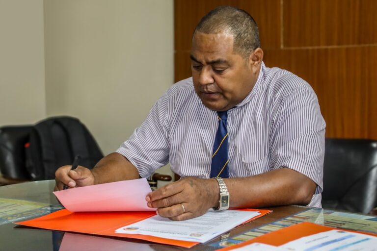 Um Homem Sentado Em Uma Mesa Com Papeis a Sua Frente _c8EEfOVRow