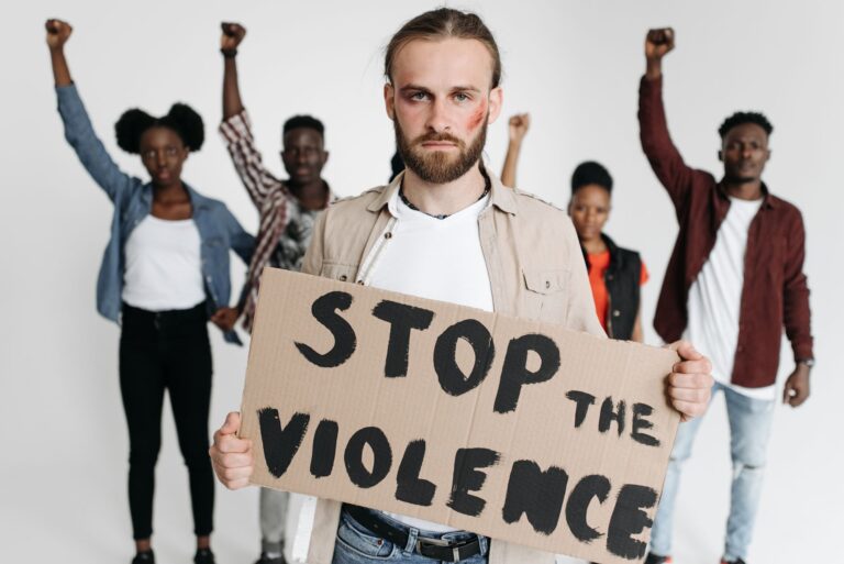 Group of activists holding a sign advocating against violence.