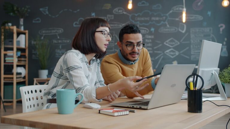 Dois Colegas Colaborando Em Um Laptop Em Uma Mesa tp_SwN8pC0A