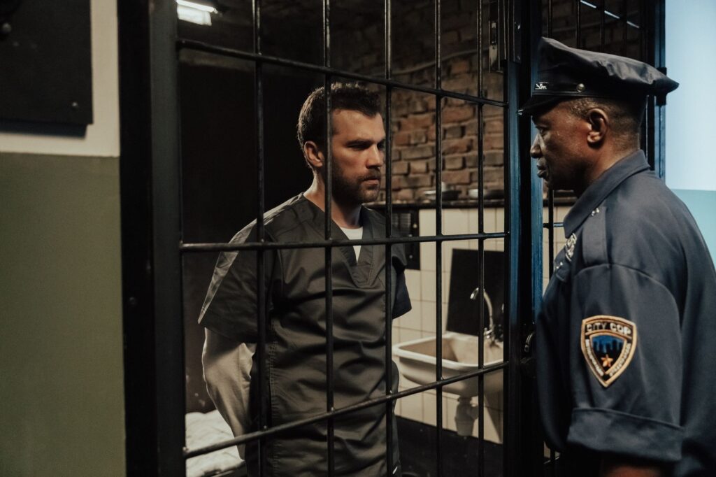A police officer and a prisoner talking through a cell door, highlighting law enforcement in action.