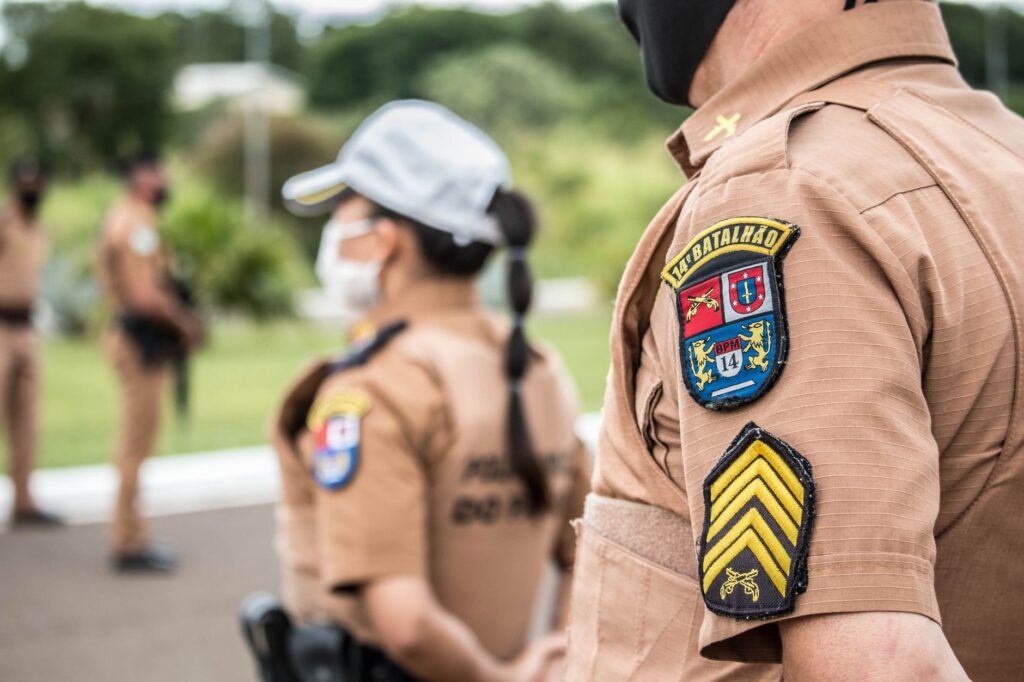 Police officers in brown uniforms standing outdoors in formation, focusing on security.