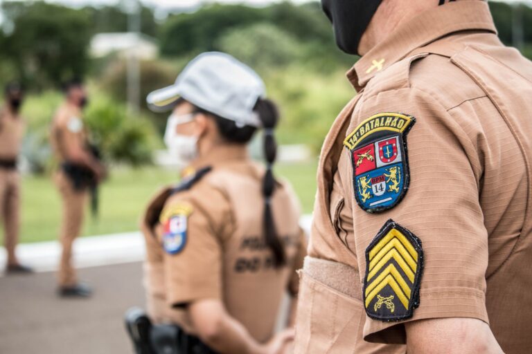 Police officers in brown uniforms standing outdoors in formation, focusing on security.