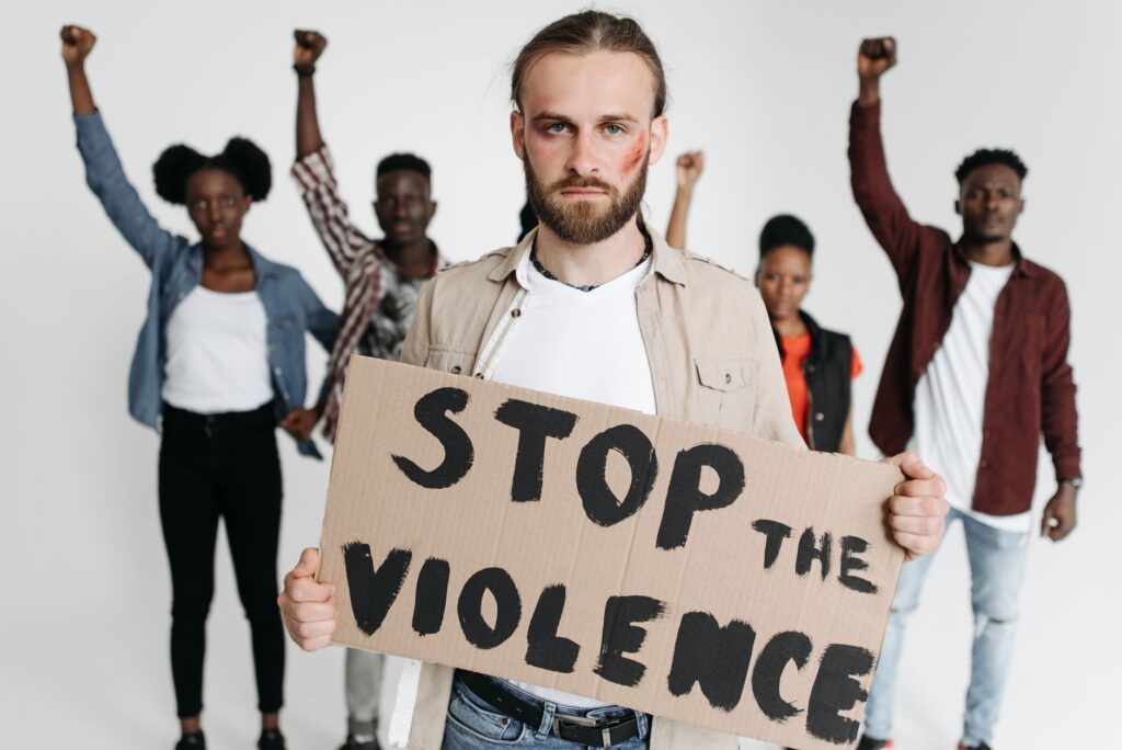 Group of activists holding a sign advocating against violence.